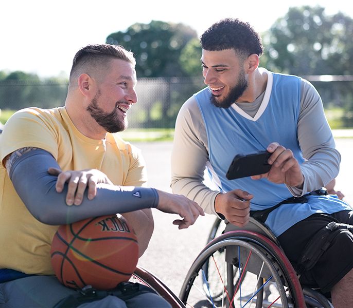 Two men playing basketball in wheelchairs