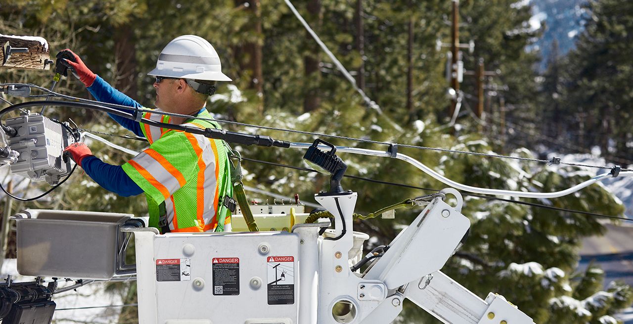 Spectrum technician working in a bucket on a broadband expansion project