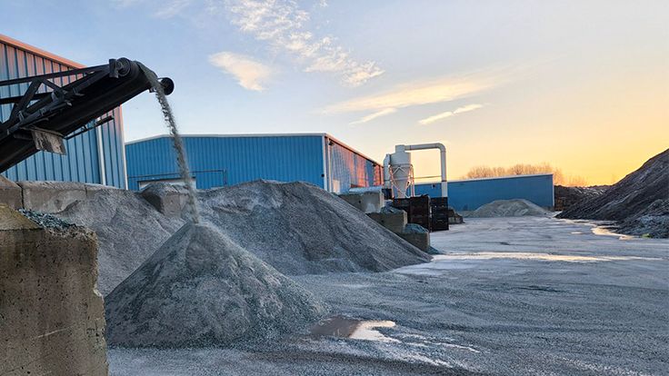 Dlubak Glass' facility in Ohio, shown from outside, with piles of materials, warehouses and conveyors